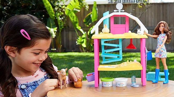 Girl Playing With Barbie Doll Egg Farm Playset in a Backyard