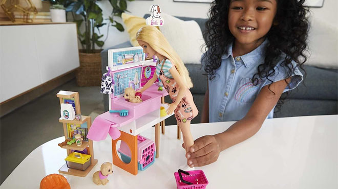 Girl Playing With Barbie Doll and Pet Boutique Playset at Home