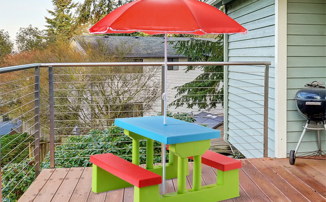 Costway 4 Seat Kids Picnic Table with Umbrella on a Balcony