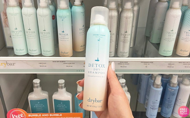 Woman Holding a Can of Drybar Detox Dry Shampoo at the Store