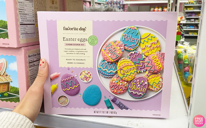 Woman Holding an Easter Egg Shaped Sugar Cookie Decorating Kit on a Shelf at Target