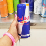 Woman Holding a red bull energy drink