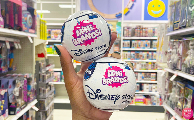 Hand Holding 5 Surprise Mini Brands Disney