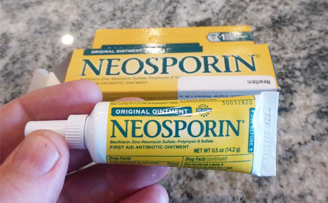 Hand Holding Neosporin Original Antibiotic Ointment