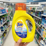 Hand Holding Tide Simply Oxi 20 Loads Inside Walgreens Store