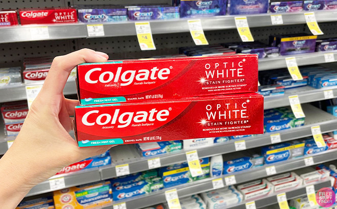 Hand Holding Two Colgate Stain Fighter Toothpastes