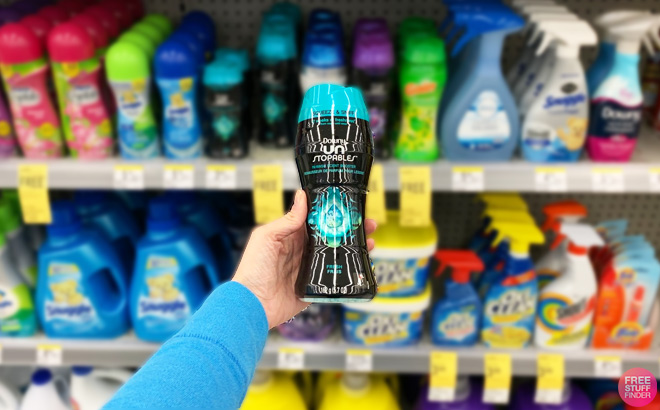 Hand Holding a Downy Unstopables Fresh In Wash Scent Boosters in Front of a Store Shelf