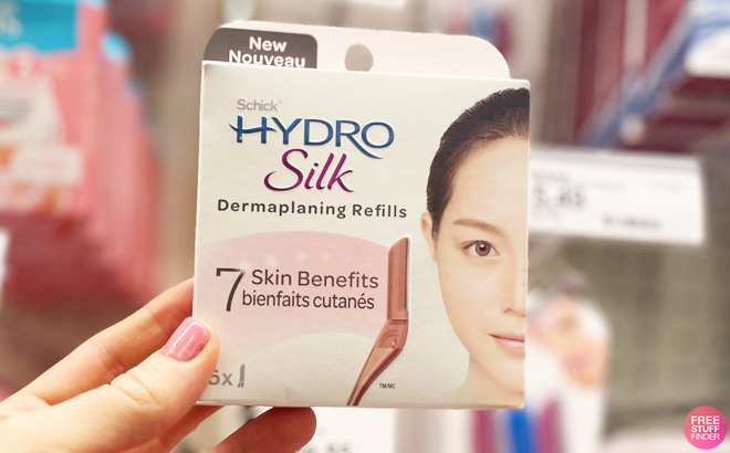 Hand Holding a Schick Hydro Silk Dermaplaning Refills in Front of the Shelf