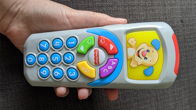 Hand Holding the Fisher Price Laugh and Learn Toy Pretend TV Control Remote