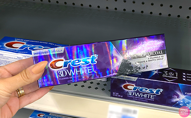 Hand holding Crest 3D White Toothpaste
