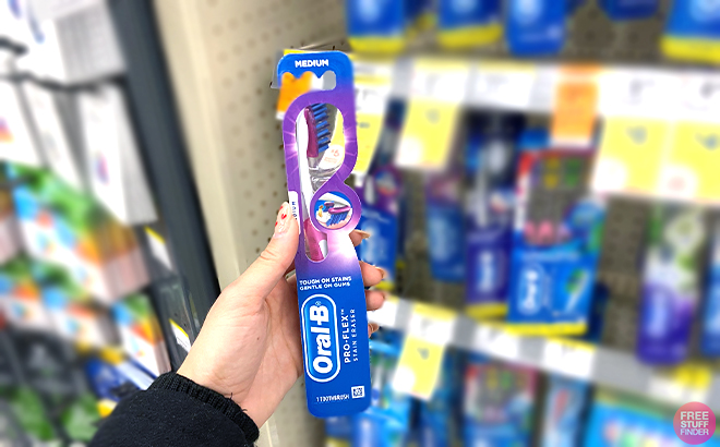 Hand holding Oral B Toothbrush