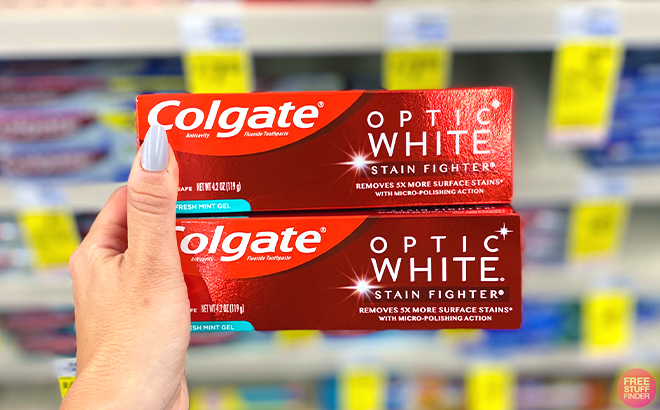 Hand holding two Colgate Optic White Toothpastes 4 2 Ounce
