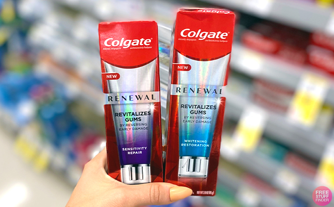Hand holding two Colgate Renewal Toothpastes