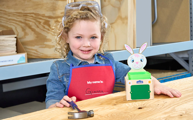 Little Girl Holding a Hammer and Making a Bunny Planter from Lowes Workshop Event