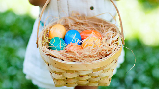 Kid Holding an Easter Basket Filled with Decorated Easter Eggs Outdoors