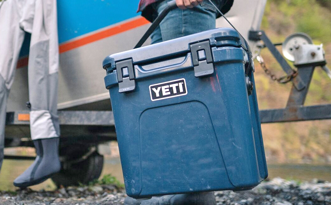Man Carrying the YETI Roadie 24 Cooler in Navy Color
