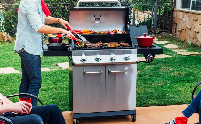 Man Grilling on a Premier Dyna Glo Free Standing 4 Burner Gas Grill