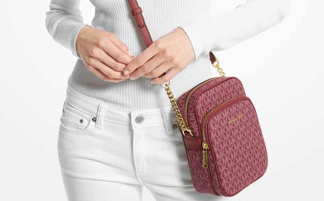 Model Wearing Michael Kors Jet Set Travel Medium Logo Crossbody Bag in Mulberry Color Model Wearing Michael Kors Jet Set Travel Medium Logo Crossbody Bag in Mulberry Color