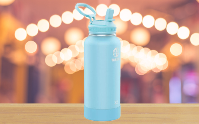 Takeya Actives Stainless Steel Water Bottle with Straw Lid Ice Blue Color on a Wooden Table