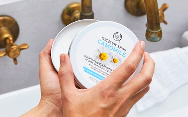Woman Opening a can of The Body Shop Chamomile Sumptuous Cleansing Butter