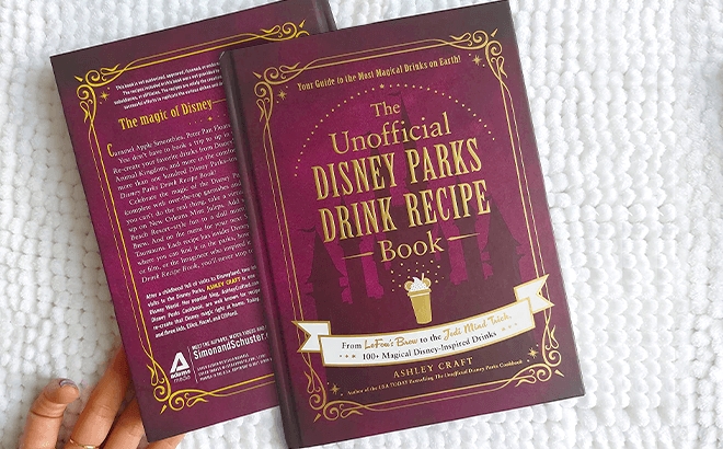 The Unofficial Disney Parks Drink Recipe Book on a White Blanket