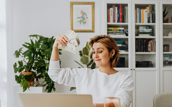 Woman Claiming Money in front of Computer