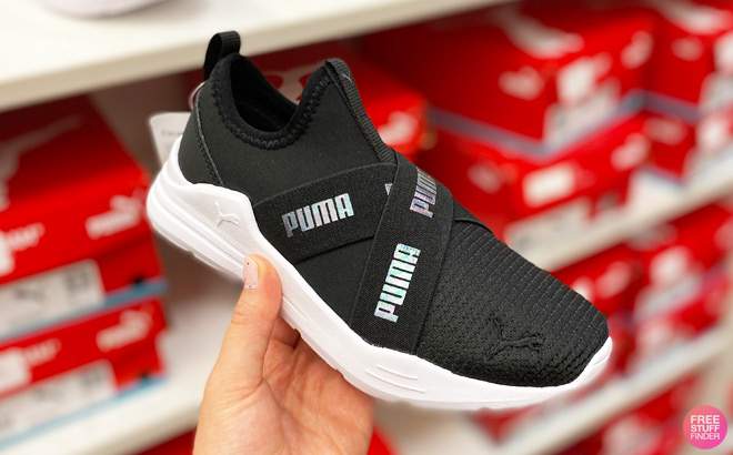 A Hand Holding Puma Slip On Girls Shoes