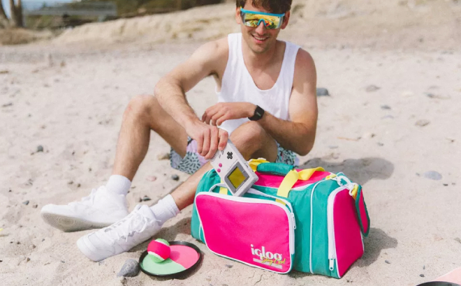 A Person Placing a Toy in the Pocket of Igloo Retro Duffel Cooler