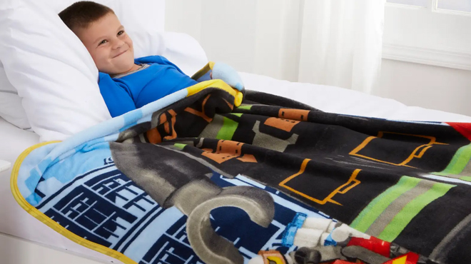 A boy under LEGO Fire Chief 46 x 60 Inch Throw