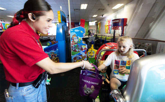 Chuck E Cheeses Employee Giving a Gift Bag to a Child