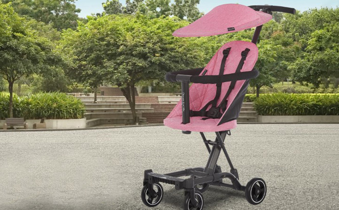 Dream On Me Pink Stroller with Canopy on a Paved Path