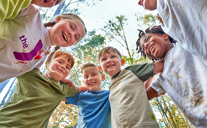 Group of Children engaged in a Hug While Smiling Outdoors