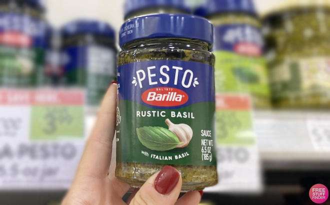 Hand Holding Barilla Pesto Sauce Jar
