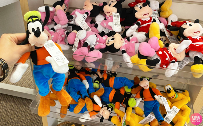 Hand Holding Disney Goofy Mini Plush and More Disney Mini Plushes in the Shelf