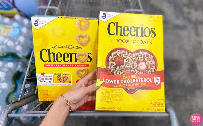 Hand Holding General Mills Cheerios Cereal in Cart at CVS