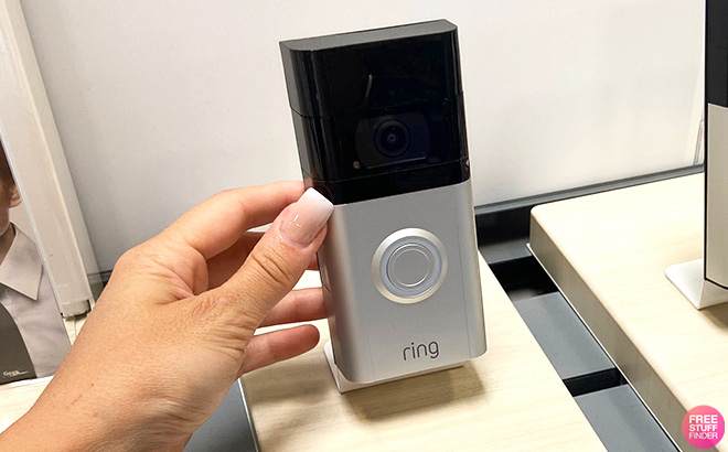 Hand Holding Ring Video Doorbell on a Store Display Shelf