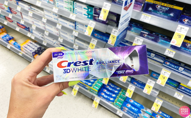 Hand Holding a Crest 3D White Brilliance Toothpaste