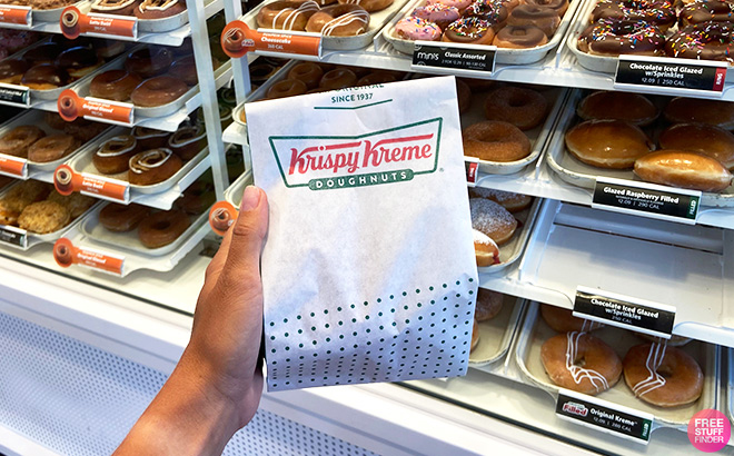 Hand holding Krispy Kreme doughnut bag