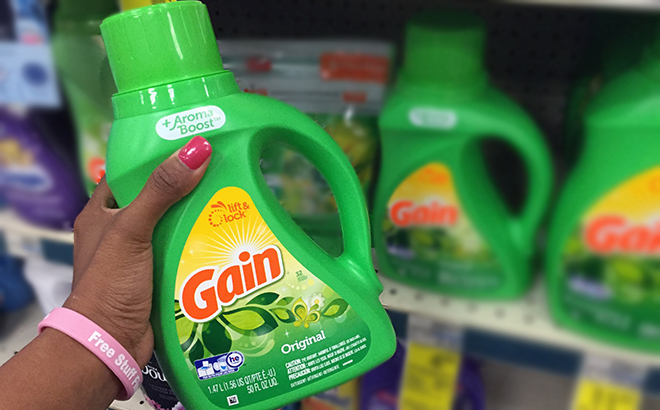 Hand holding one Gain Liquid Laundry Detergent 32 Loads