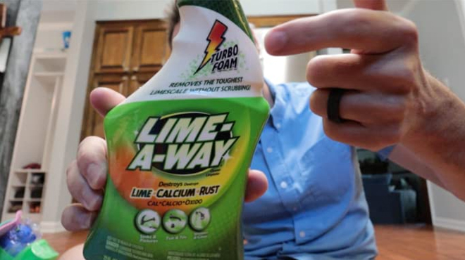 Man holding a bottle of Lime A Way Bathroom Cleaner Spray Man holding a bottle of Lime A Way Bathroom Cleaner Spray
