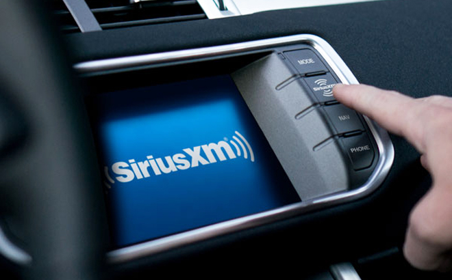 A Person Clicking on Their Car Dashboard with SiriusXM on the Display