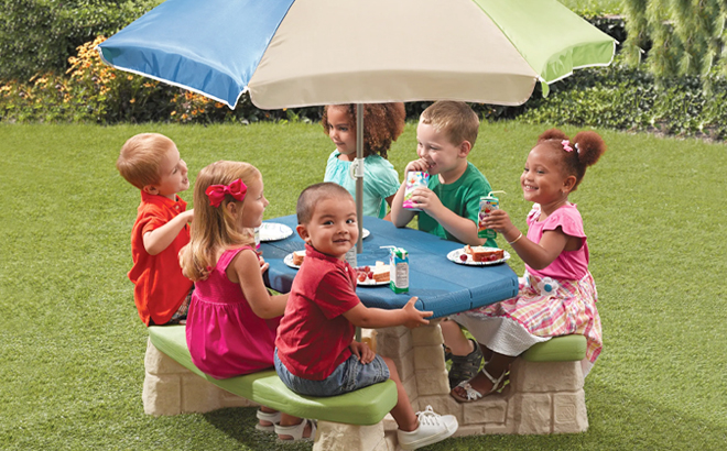 Six Kids Sitting on Step2 Picnic Table Chair Set With Umbrella in the Garden