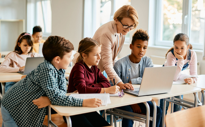 Teacher Demonstrating on a Laptop to Students in a Classroom