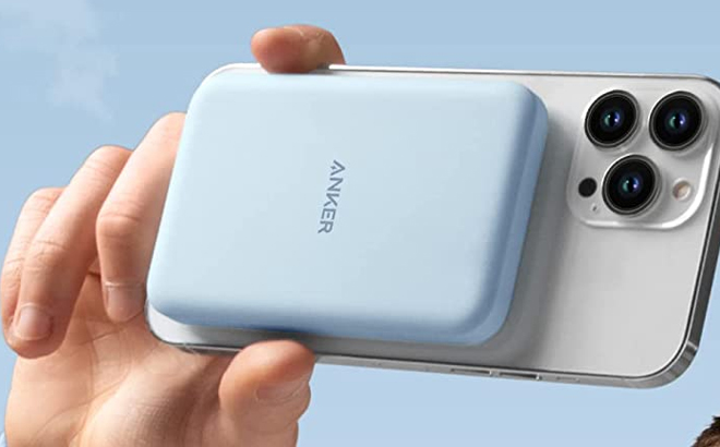 a Person Holding a Phone with a Blue Anker Magnetic Battery Portable Charger Attached to it