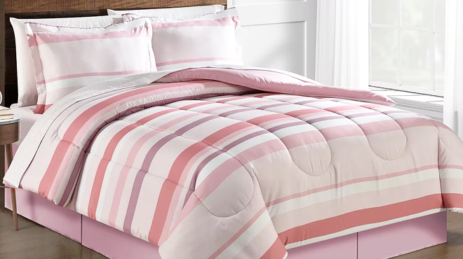 A Bed Covered with Fairfield Square Collection Reversible 8 Piece Comforter Set in Pink