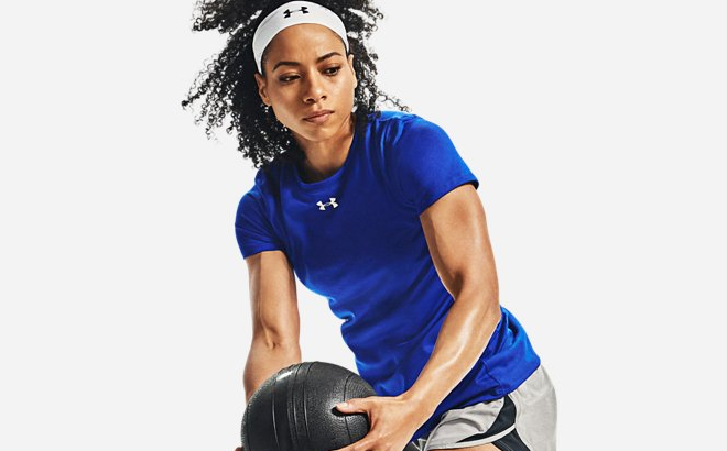 A Woman Wearing Under Armour Womens Short Sleeve Locker 2 0 Tee in Royal Blue Color and Holding a Ball