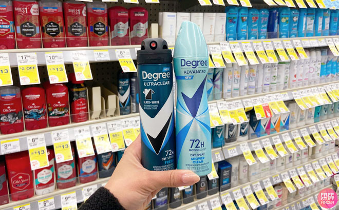 Hand Holding Degree Dry Spray Black and White and Degree Dry Spray Shower Clean in Front of a Shelf at Walgreens