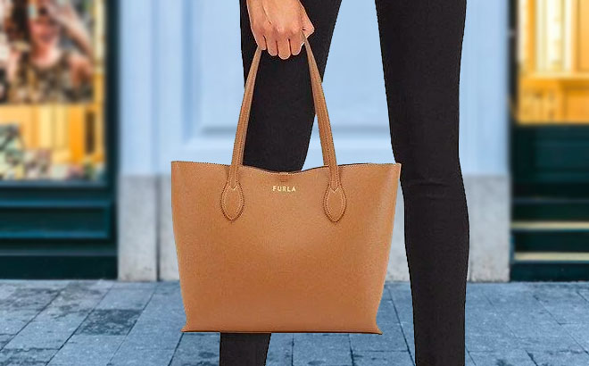Hand Holding Furla Era Tote Bag in Front of a Store