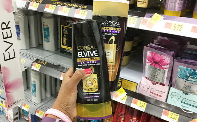Hand Holding LOreal Elvive Shampoo and Conditioner