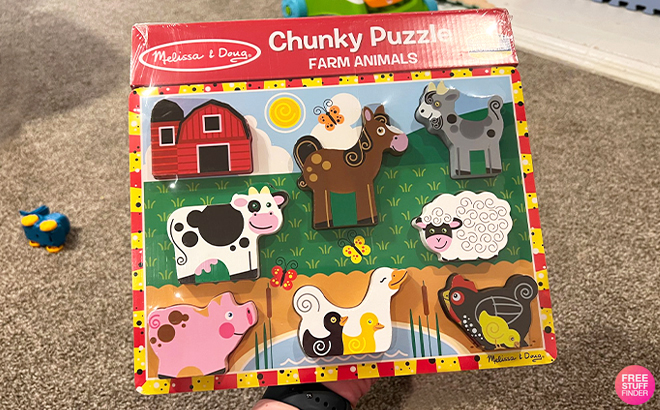 Hand Holding Melissa & Doug Chunky Puzzle with Seven Farm Animals